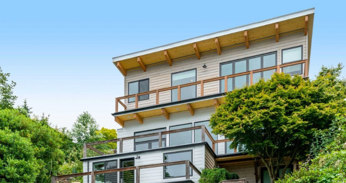 Magnolia Seattle waterfront home fully reclad with new bevel cedar siding, ColorPlus Hardie plank siding, windows, and railings following saltwater damage.