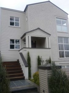 Before photo of a Madison Valley Seattle home showing the original exterior siding, windows, and entry prior to a full exterior envelope renovation.
