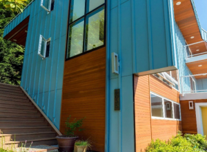 Modern home exterior with vertical wood-style siding and panel cladding, showing clean trim transitions and durable installation details.