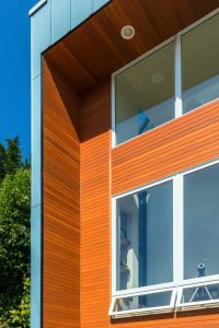 Close-up view of clear 1x4 T&G cedar siding showcasing its natural grain and smooth horizontal alignment against adjacent metal trim.