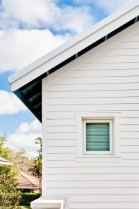 Close-up of the side of a house showing off white fiber cement siding
