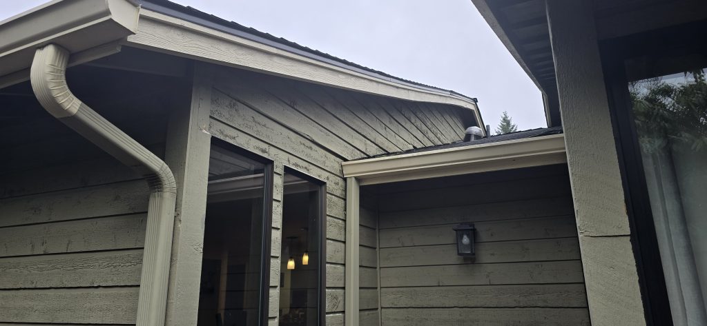 1x8 TK cedar channel siding showing staining and deterioration from water intrusion; no head flashing above windows.