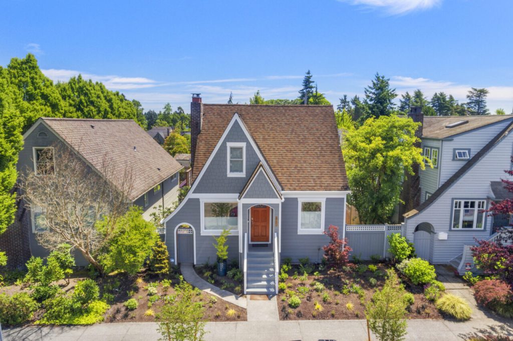 Green Lake Seattle home with newly reclad exterior featuring Hardie plank siding, wood shingle accents, new windows, trim, and a rebuilt front porch.
