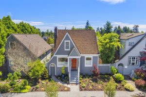Green Lake Seattle home with newly reclad exterior featuring Hardie plank siding, wood shingle accents, new windows, trim, and a rebuilt front porch.