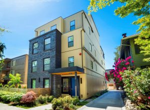Multi-family apartment building with panel siding, brick façade integration, and watertight building envelope installation by Synapse Construction in Seattle.