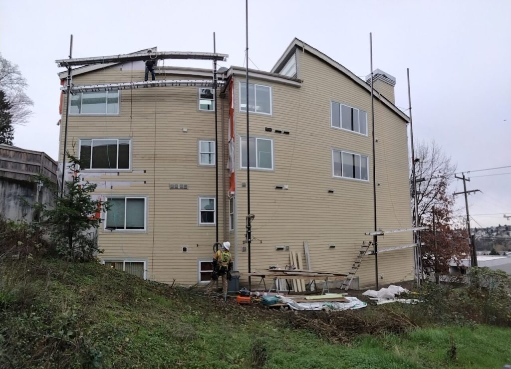 Queen Anne condominium undergoing exterior renewal including roof replacement, siding removal, rot repair, Milgard vinyl window upgrades, and envelope remediation by Synapse Construction in Seattle.