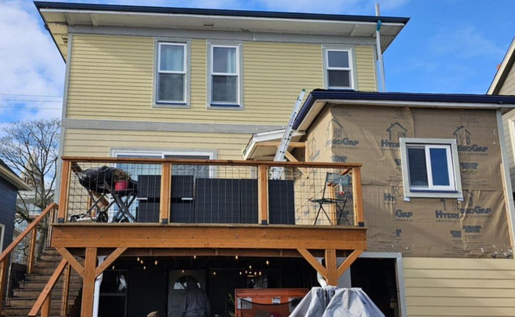 Emergency flashing repair in progress exposing roof-to-wall and window flashing details during water intrusion repair at Seattle-area home.