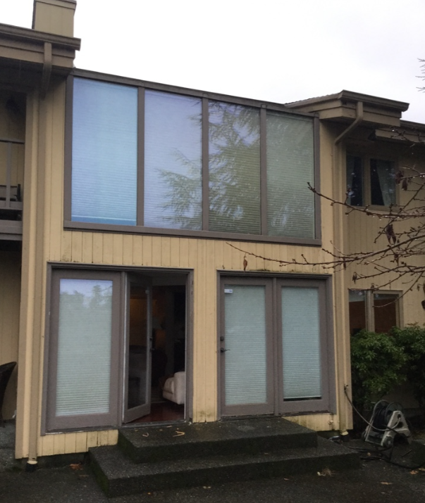 Window wall at roof transition scheduled for replacement, including roofing extensions and skylight installation to improve waterproofing and drainage.